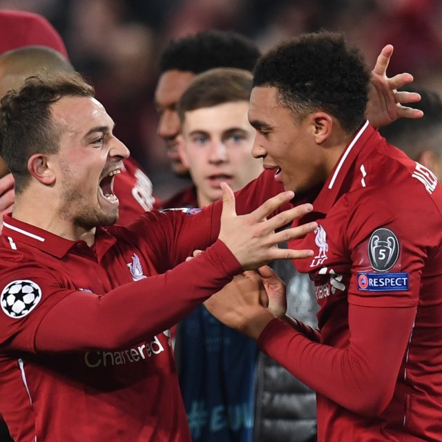 Trent Alexander-Arnold merayakan asisst legendarisnya saat melawan Barcelona bersama Xherdan Shaqiri. Foto: Paul ELLIS / AFP