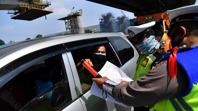 Petugas kepolisian memeriksa warga yang melintas di tol Jakarta-Cikampek, Cikarang Barat, Jawa Barat, Kamis (7/5/2020).   Foto: ANTARA/Sigid Kurniawan