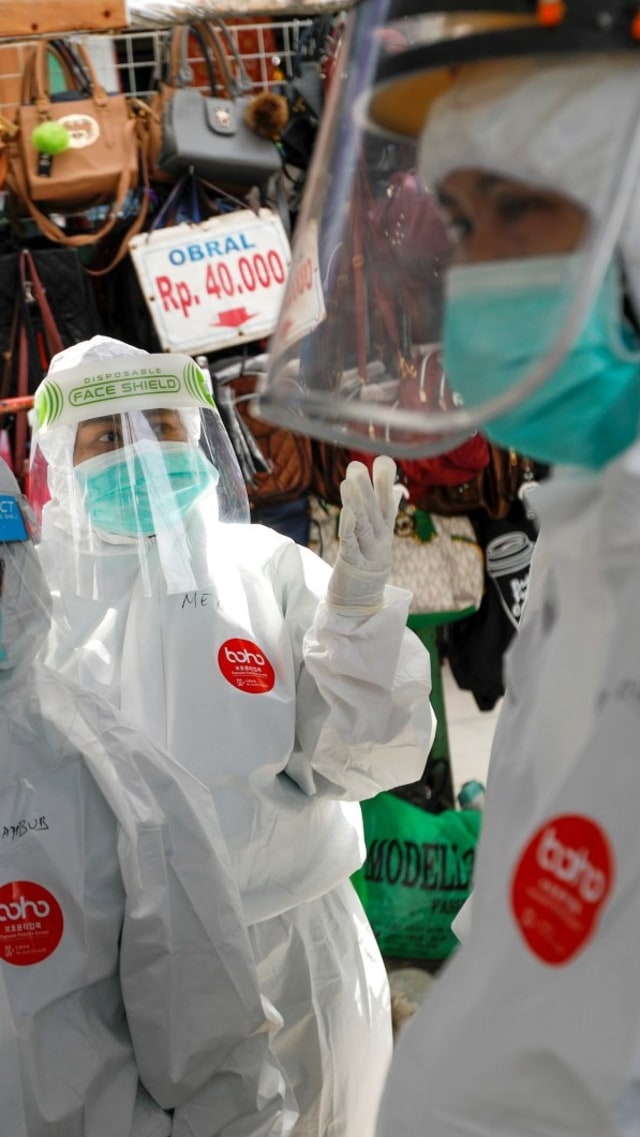 Petugas medis dengan APD lengkap bersiap untuk mengambil sampel swab dari warga di pasar tradisional di Bogor, Jumat (8/5). Foto:  REUTERS / Willy Kurniawan