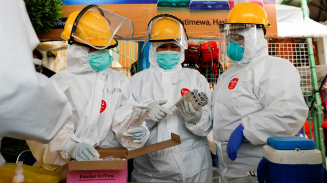 Petugas medis dengan APD lengkap bersiap untuk mengambil sampel swab dari warga di pasar tradisional di Bogor, Jumat (8/5). Foto: REUTERS / Willy Kurniawan