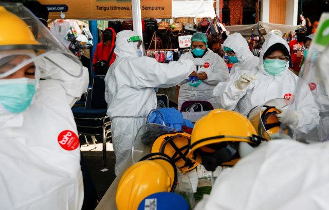 Petugas medis dengan APD lengkap bersiap untuk mengambil sampel swab dari warga di pasar tradisional di Bogor, Jumat (8/5). Foto:  REUTERS / Willy Kurniawan