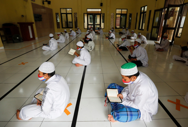 Para santri mengaji dengan menggunakan masker dan menerapkan jarak fisik di Pondok Pesantren Daarul Qur'an Al Kautsar, Bogor. Foto: REUTERS/Willy Kurniawan
