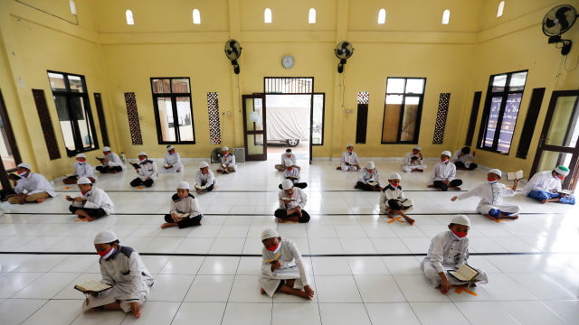 Para santri mengaji dengan menggunakan masker dan menerapkan jarak fisik di Pondok Pesantren Daarul Qur'an Al Kautsar, Bogor. Foto: REUTERS/Willy Kurniawan