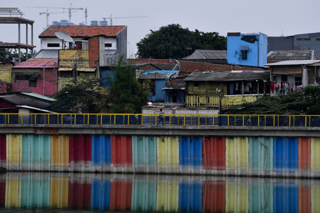 Warga beraktivitas di rumahnya berlatar belakang hunian bertingkat di kawasan Sunter, Jakarta Utara, Sabtu (9/5/2020). Foto: ANTARA FOTO/Sigid Kurniawan