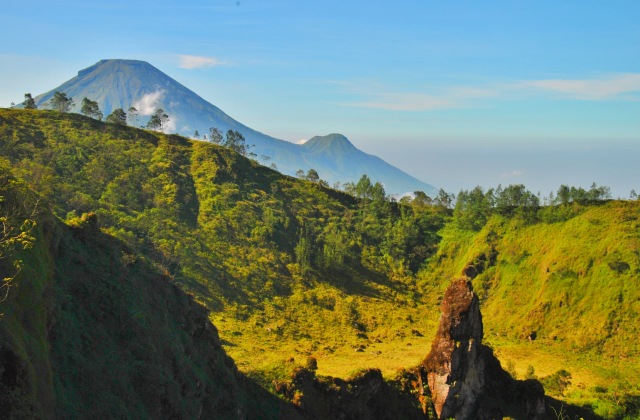 Batu runcing seperti menhir di tengah kawah wurung ciri khas dari Gunung Pakuwaja. Tampak Gunung Sindoro dan Gunung Kembang mengintip di baliknya. Foto: Harley Sastha