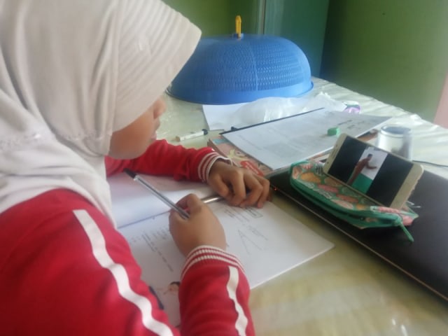 Anak belajar di rumah dengan ponsel orangtuanya. Dok. acehkini