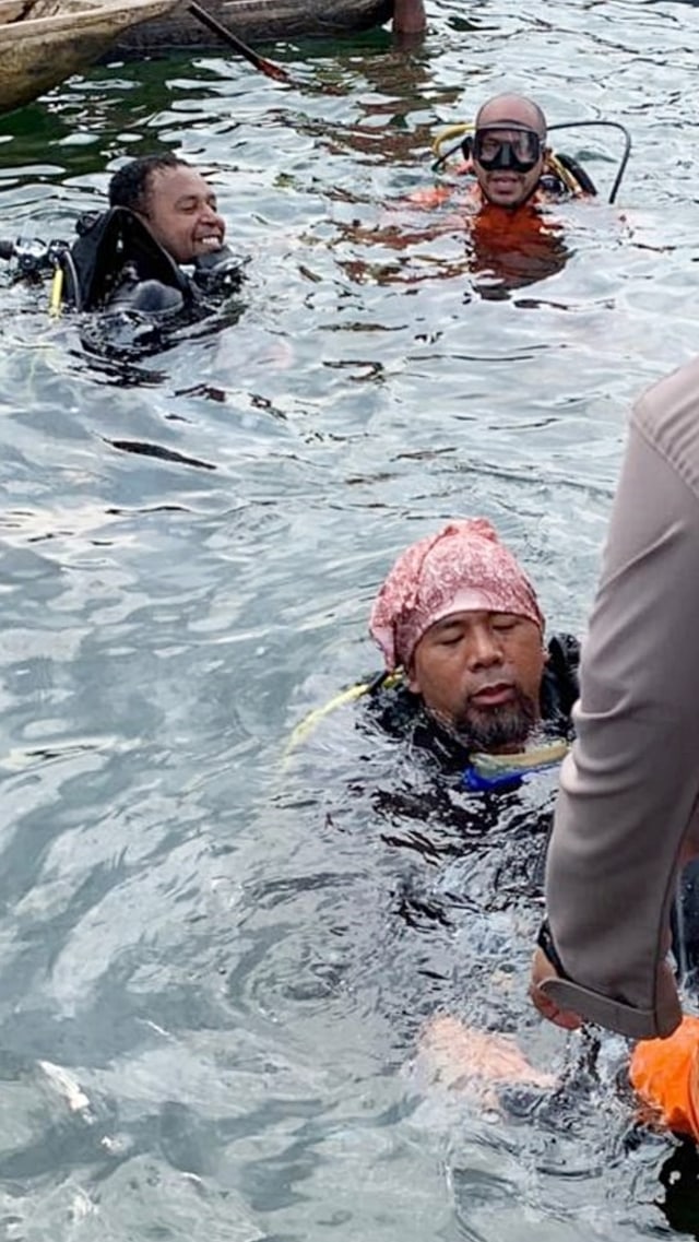 Penyelam dan SAR gabungan saat evakuasi jenazah pilot pesawat Cessna milik MAF yang terperangkap di badan pesawat. Foto: Dok. Polda Papua