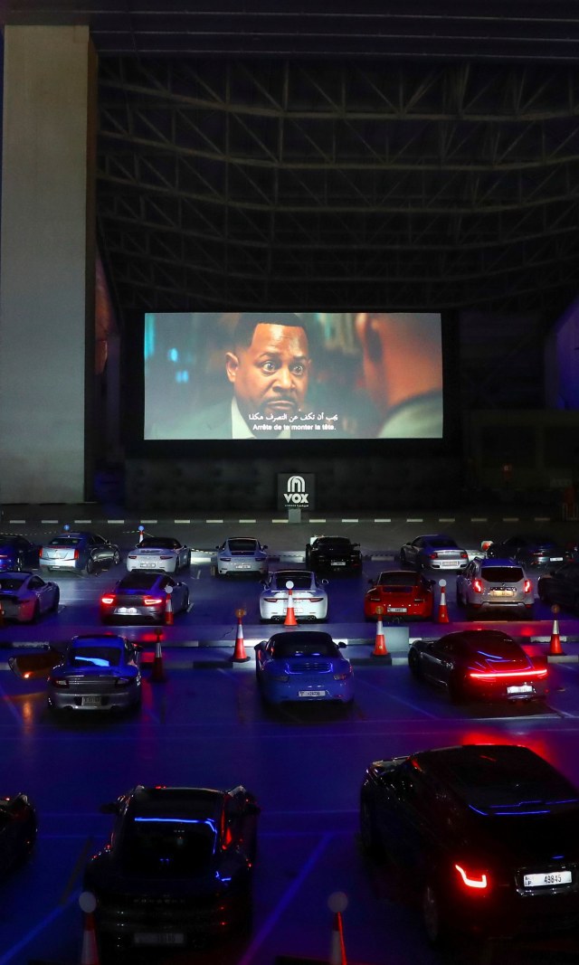 Orang-orang duduk di mobil mereka sambil menonton film di bioskop drive-in di Mall of the Emirates di Dubai, (13/5). Foto: REUTERS/Ahmed Jadallah
