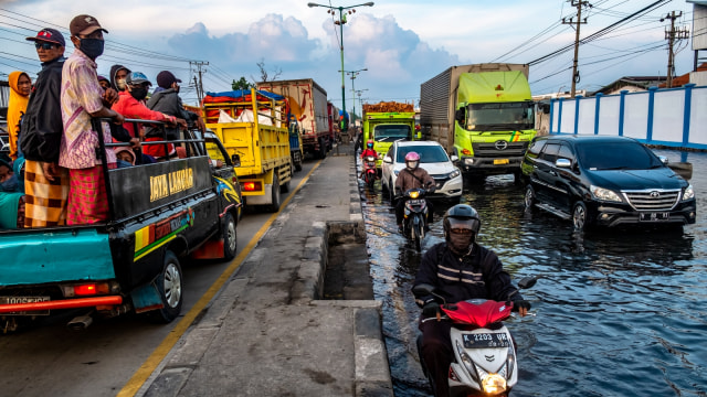 Kendaraan bermotor menembus jalan raya pantura Demak KM 8 ruas Demak-Semarang yang tergenang rob di Demak, Jawa Tengah, Rabu (13/5). Foto: ANTARA FOTO/Aji Styawan