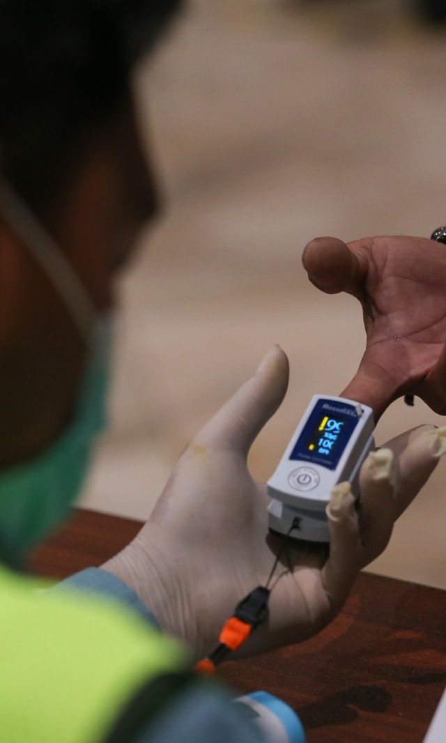 Petugas memeriksa kesehatan calon penumpang sebelum pemberangkatan di Terminal 2 Bandara Soekarno Hatta, Tangerang, Banten, Jumat (15/5). Foto: ANTARA FOTO/Fauzan