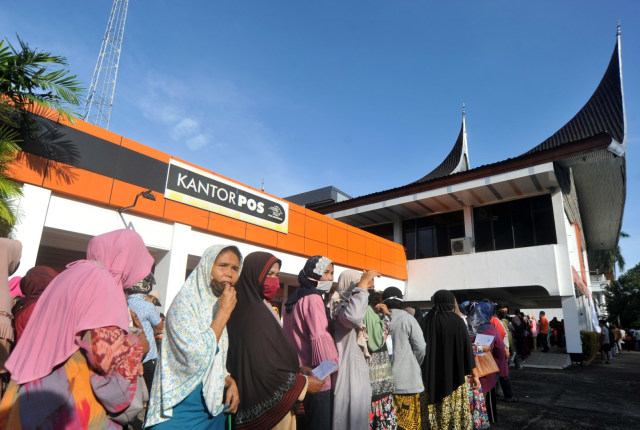 Warga mengantre penyaluran bansos tunai Kemensos, di Kantor Pos Khatib Sulaiman, Padang, Jumat (15/5). Foto: ANTARA FOTO/Iggoy el Fitra