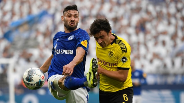 Gelandang Schalke, Daniel Caligiuri (kiri), dan gelandang Dortmund, Thomas Delaney, berebut bola dalam Revierderby. Foto: AFP/Ina Fassbender