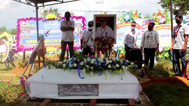 Sejumlah teman kerja berswafoto di makam Joice Lin di TPU Sereh Sentani. Foto:  Levin