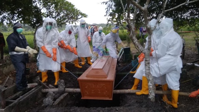 Petugas RSUD Bojonegoro bersama masyarakat setempat saat memakamkan jenazah ODP warga Desa Ngunut Kecamatan Dander Bojonegoro di pemakaman desa setempat. Sabtu (16/05/2020)