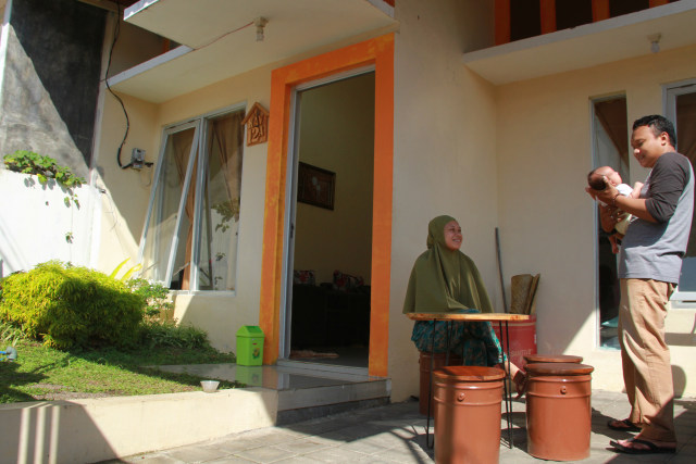 Ipung, 29 dan istri 26 sedang berjemur bersama anaknya yang baru lahir sekitar satu bulan lalu. Kegiatan ini, setiap pagi mereka lakukan di halaman rumahnya.