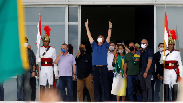 Presiden Brasil Jair Bolsonaro menyapa pendukungnya selama aksi protes di Brasilia, Brasil. Foto: REUTERS / Adriano Machado