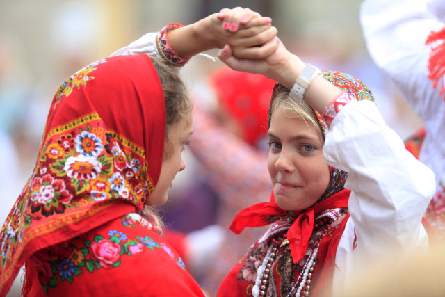 Warga mengenakan pakaian tradisional pulau Kihnu saat mereka menari pada hari budaya tradisional di Tallinn. Foto: REUTERS/Ints Kalnins