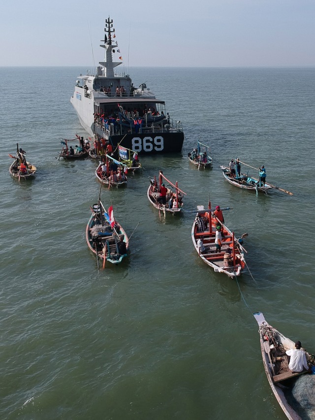 Sejumlah prajurit Pangkalan Utama Angkatan Laut (Lantamal) V melalui KRI Gulamah-869 membagikan paket sembako di Selat Madura, Jawa Timur. Foto: ANTARA FOTO/Mayor Laut (P) Arys Susanto