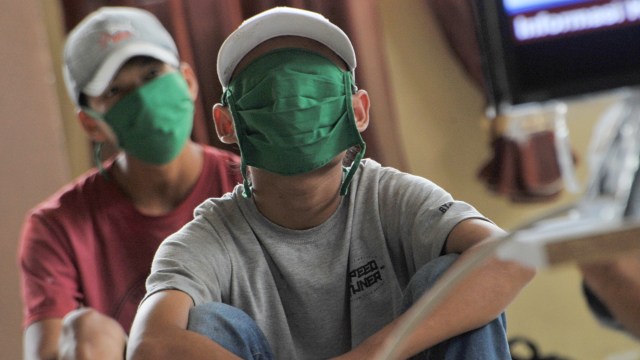 Ilustrasi: Sejumlah warga yang terjaring razia masker diberikan edukasi melalui tayangan informasi terkait COVID-19, di Asrama PGRI Plaju Palembang, Sumsel, Selasa (19/5). Foto: ANTARA FOTO/Feny Selly