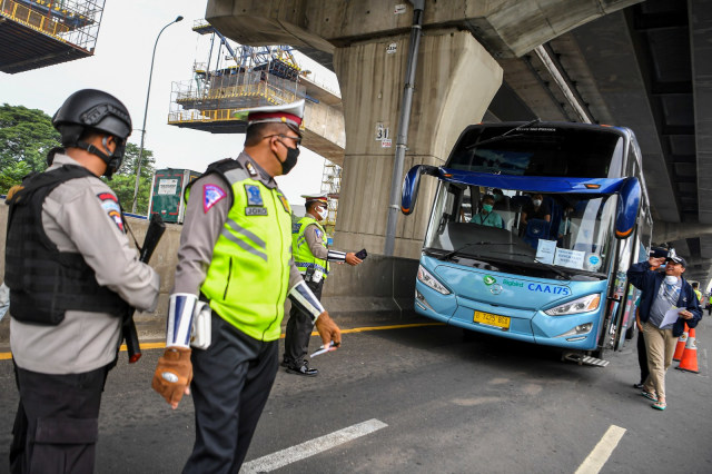 Petugas kepolisian mengarahkan kendaraan untuk keluar Tol Cikarang Barat, di ruas Tol Jakarta-Cikampek, Jawa Barat, Selasa (19/5). Foto: ANTARA FOTO/Nova Wahyudi
