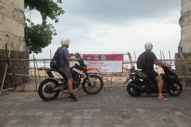 Para turis yang tersisa hanya bisa menatap pantai Kuta dari luar pagar - ZTE
