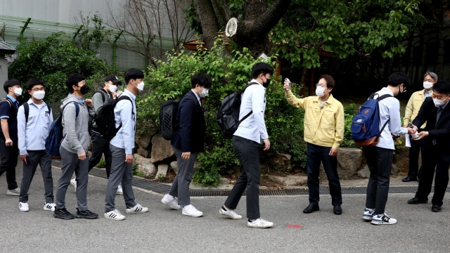 Pelajar SMA di Korea Selatan kembali masuk sekolah. Foto: Getty Images/Chung Sung-Jun
