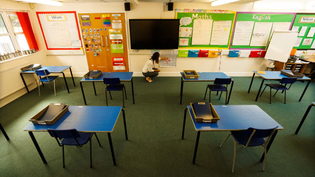 Guru mempersiapkan ruangan kelas untuk pelajar saat sekolah kembali dibuka di Watlington, Inggris. Foto: Reuters/EDDIE KEOGH