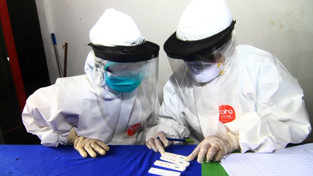 Dua petugas medis memeriksa hasil dari sejumlah alat test rapid test COVID-19 di kawasan Pasar Seruni di Jalan Panglima Aim, Pontianak, Kalimantan Barat. Foto: ANTARA FOTO/Jessica Helena Wuysang