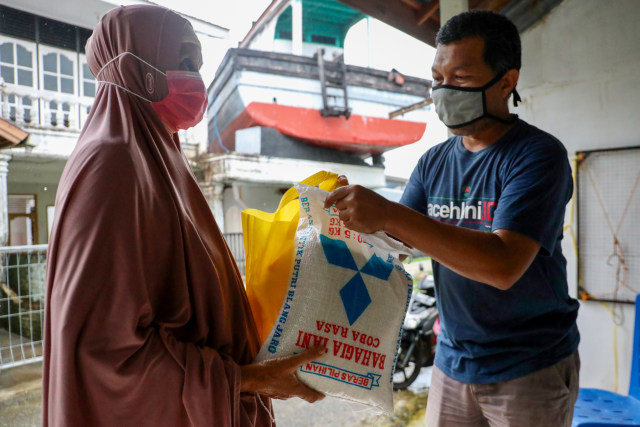 Menyerahkan paket bantuan kepada pemandu wisata di Lampulo. Foto: Suparta/acehkini 