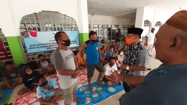 M Hasan Bay (peci hitam) saat mengunjungi warga Gorontalo yang tertahan di Pelabuhan Ahmad Yani Ternate. Foto: Faris Bobero/cermat