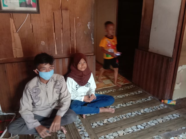 Ketiga anak yatim piatu saat berada di kontrakan mereka ketika hari pertama lebaran.