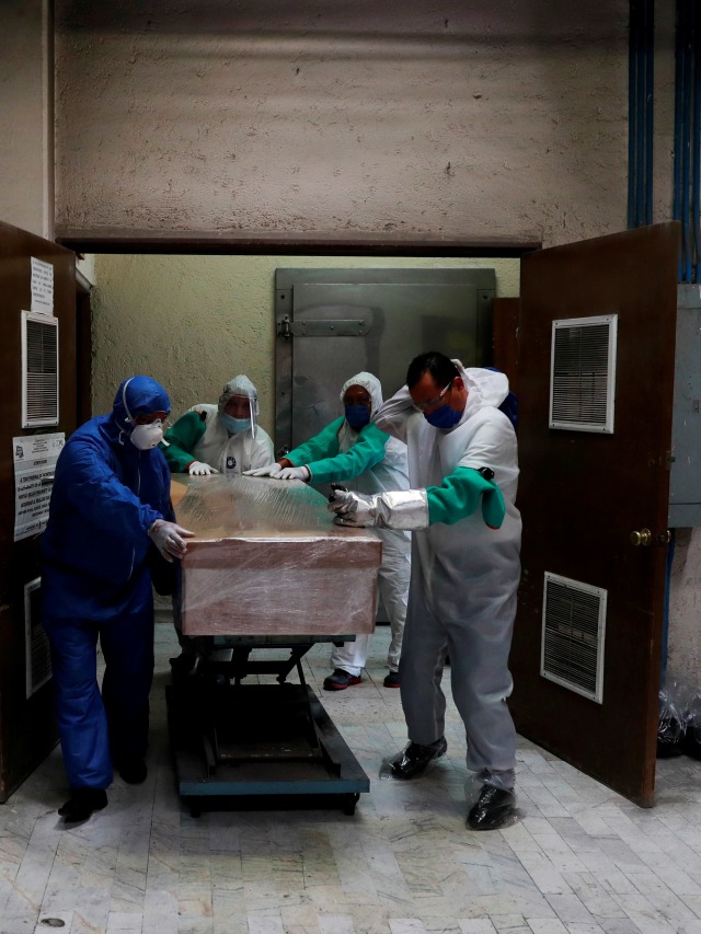 Petugas membawa jenazah pasien virus corona di krematorium San Isidro, Meksiko.  Foto: REUTERS/Carlos Jasso