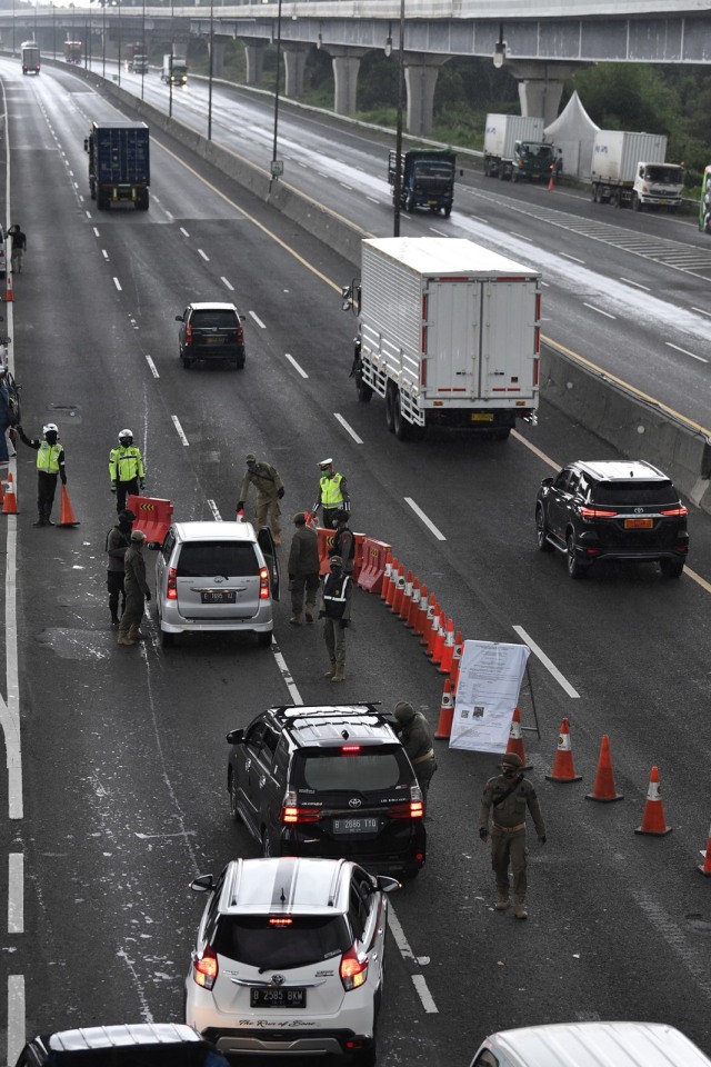 Petugas memeriksa surat kelengkapan syarat masuk wilayah Jabodetabek di KM 47 Tol Cikampek-Jakarta, Jawa Barat, Rabu (27/5). Foto: ANTARA FOTO/Puspa Perwitasari