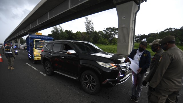 Petugas memeriksa surat kelengkapan syarat masuk wilayah Jabodetabek di KM 47 Tol Cikampek-Jakarta, Jawa Barat, Rabu (27/5). Foto: ANTARA FOTO/Puspa Perwitasari