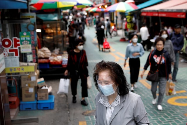 Orang-orang memakai masker untuk menghindari penyebaran virus corona di Seoul, Korea Selatan, Kamis (28/5). Foto: REUTERS/Kim Hong-Ji