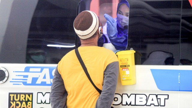 Warga mengikuti test swab COVID-19 menggunakan mobil tes polymerase chain reaction (PCR) atau Mobile Combat COVID-19 di RSUD Sidoarjo, Jawa Timur, Kamis (28/5). Foto: ANTARA FOTO/Umarul Faruq