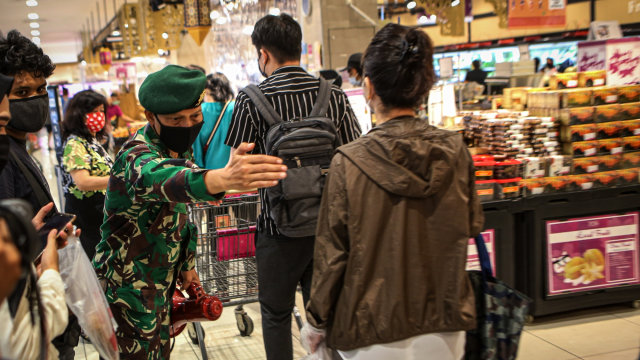 Personel TNI memberikan imbauan kepada pengunjung untuk tetap menjaga jarak di AEON Mall, Tangerang, Banten, Jumat (29/5/2020). Foto: ANTARA FOTO/Fauzan