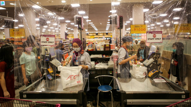 Petugas kasir melayani konsumen dari balik sekat plastik di AEON Mall, Tangerang, Banten, Jumat (29/5/2020). Foto: ANTARA FOTO/Fauzan