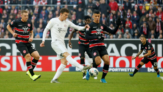 Pemain Bayern Muenchen Benjamin Pavard (tengah) menendang ke arah gawang Fortuna Dusseldorf di Stadion Merkur Spiel-Arena, Dusseldorf, Jerman. Foto: REUTERS / Leon Kuegeler