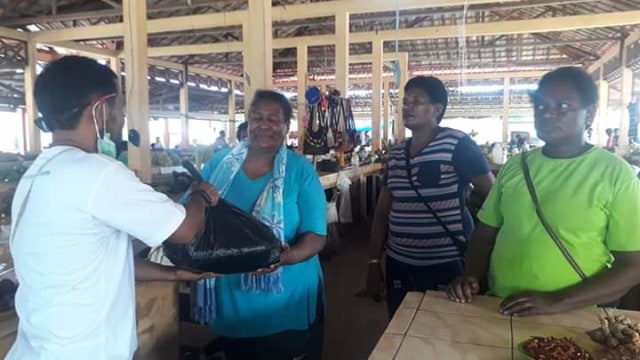 Koresponden Balleo News Biro Kaimana Arfat Jempot saat menyerahkan sembako dari Kumparan kepada salah satu pedagang sayur di Kaimana. Foto: Arfat Jempot