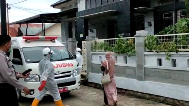 Tim medis menjemput anggota keluarga pasien positif COVID-19 untuk tes swab, Jumat (29/5). Foto: Warga/WAG mejahitam