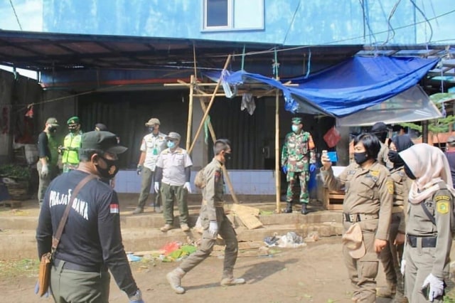 Petugas berjaga di Pasar Cileungsi yang tutup sementara.  Foto: Dok. Pemkab Bogor