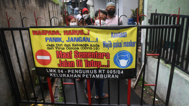 Warga memasang spanduk himbauan saat menutup jalan pada simulasi pelaksanaan Pembatasan Sosial Berskala Lokal (PSBL) di RT 05 RW 04, Petamburan. Foto: ANTARA FOTO/Akbar Nugroho Gumay