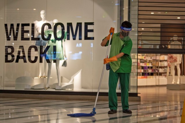 Petugas bermasker dan berpelindung wajah membersihkan lantai di Mal Central Park, Jakarta, Rabu (3/6/2020). Foto: ANTARA FOTO/Aditya Pradana Putra
