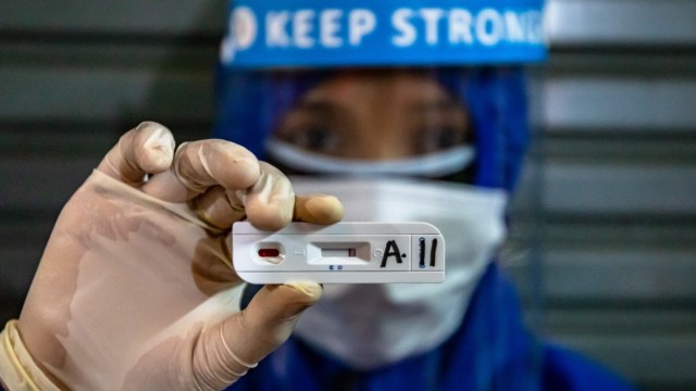 Petugas medis menunjukkan hasil negatif pada alat diagnostik cepat (rapid test) COVID-19 usai memeriksa salah satu pedagang di Pasar Babadan, Semarang. Foto: ANTARA FOTO/Aji Styawan