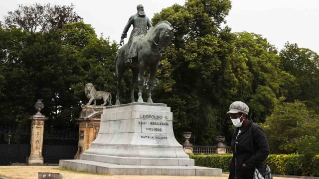 Seseorang berjalan melewati patung Raja Belgia Leopold II, dekat Istana Kerajaan Brussels, di Brussels Foto: Reuters/YVES HERMAN
