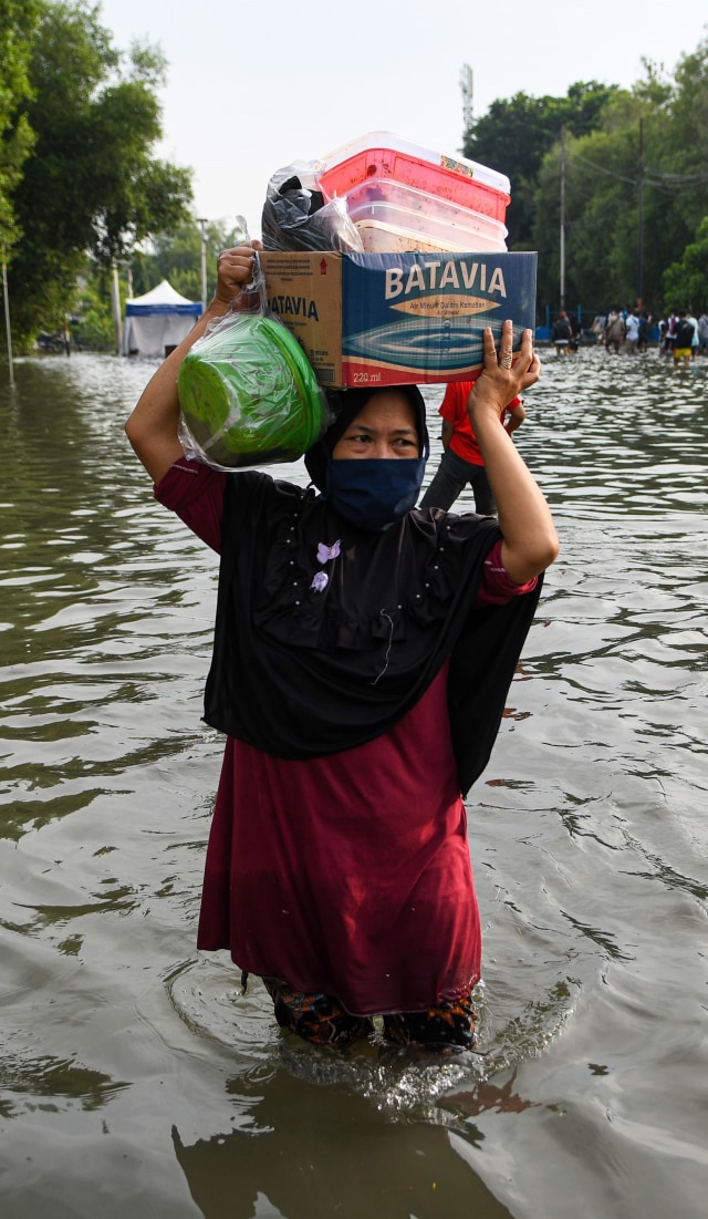 Warga melintasi banjir air rob di kawasan Muara Baru, Penjaringan, Jakarta Utara, Jumat (5/6). Foto: ANTARA FOTO/M Risyal Hidayat