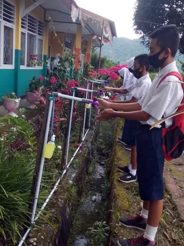 Siswa SMP di Modayag Kabupaten Boltim mencuci tangan sebelum masuk kelas (foto: istimewa)