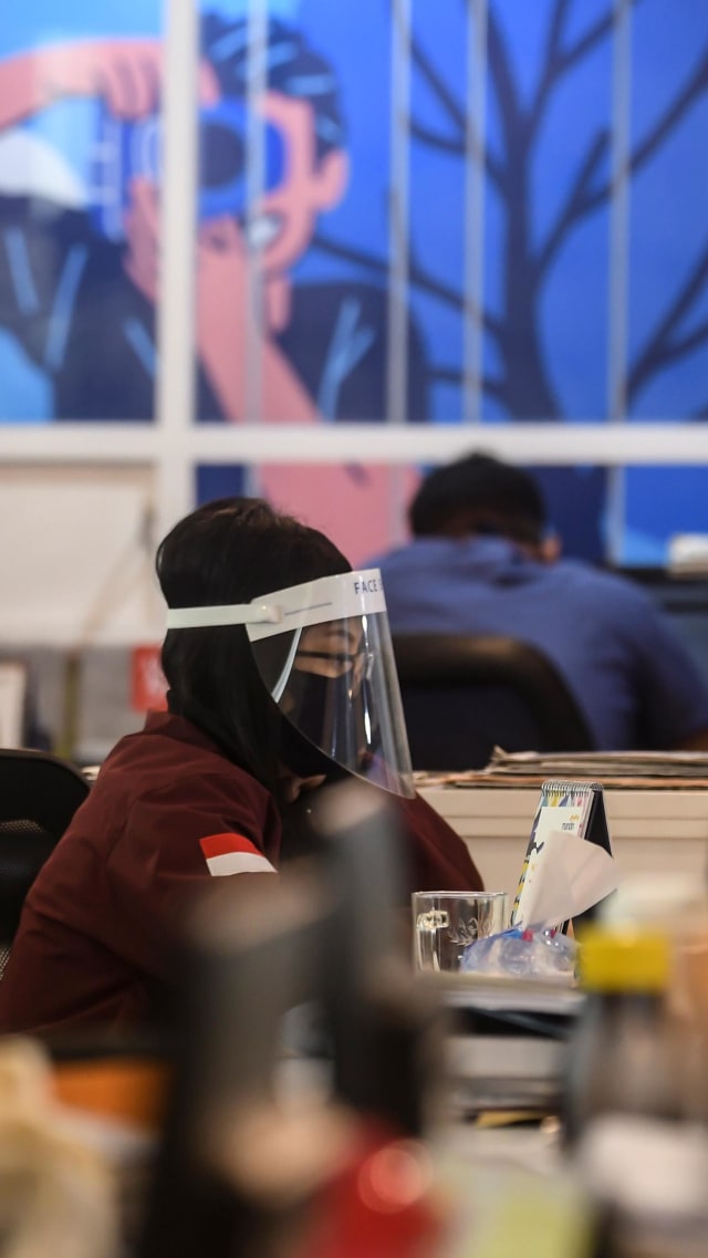 Karyawan menggunakan pelindung wajah dan masker saat melakukan aktivitas di pusat perkantoran, kawasan SCBD, Jakarta, Senin (8/6/2020). Foto: Muhammad Adimaja/ANTARA FOTO