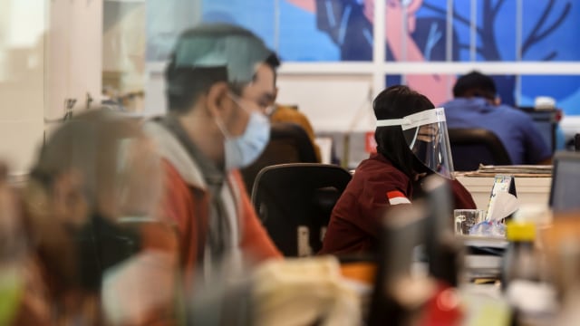 Karyawan menggunakan pelindung wajah dan masker saat melakukan aktivitas di pusat perkantoran, kawasan SCBD, Jakarta, Senin (8/6/2020). Foto: Muhammad Adimaja/ANTARA FOTO